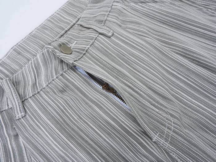 Close-up of the waistband and front zipper on gray striped wide-leg pants
