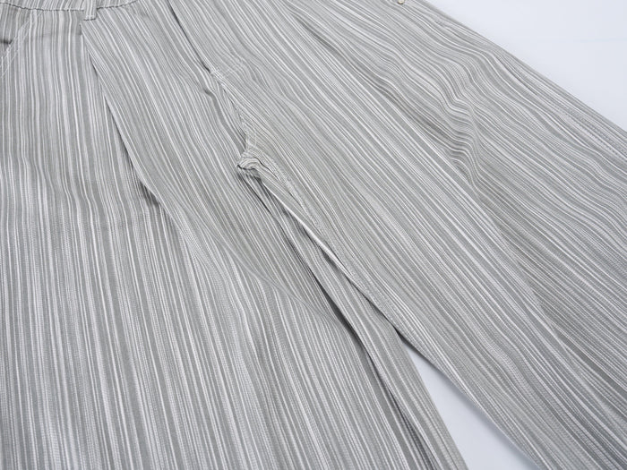 Wide-leg pants close-up showing side seam and flowing striped fabric