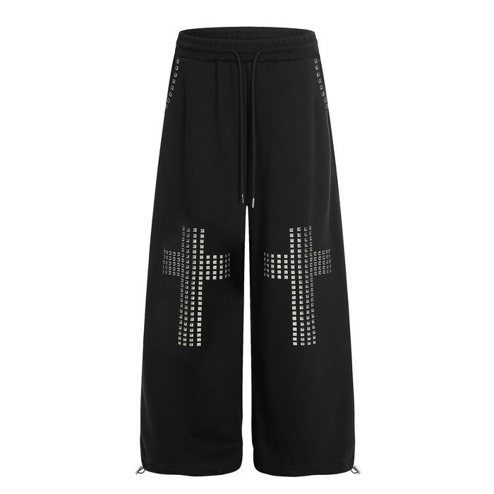 Black wide-leg sweatpants with silver studded cross details on the legs, front view