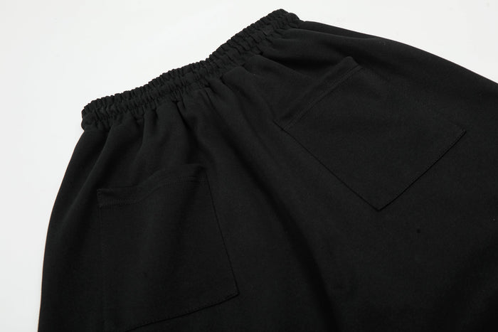 Close-up of back pocket and waistband on black wide-leg sweatpants