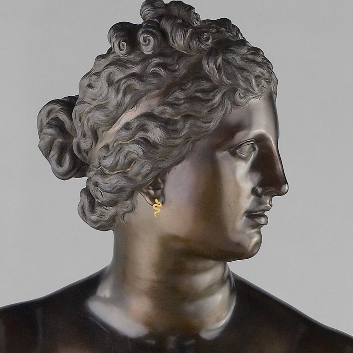 Serpent stud earrings on a bronze bust of a woman