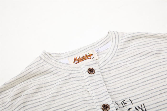 Close-up of the cream striped Henley collar, button placket, and top brown button