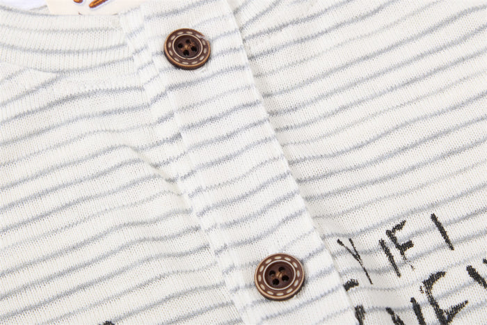 Detailed view of two brown buttons on the cream and gray striped Henley placket