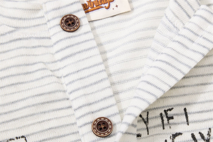 Close-up of the Henley placket with brown buttons, striped fabric, and partial graphic