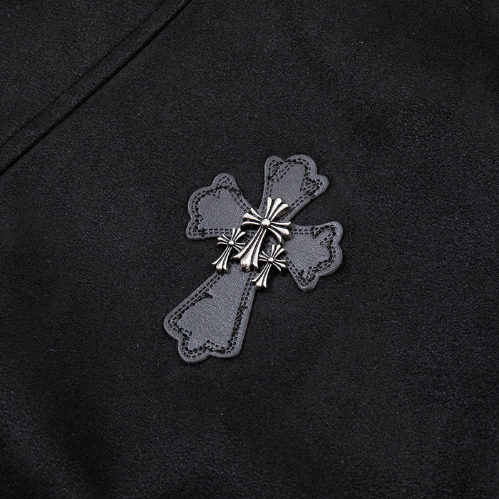 Close-up of an ornate gray cross-shaped patch with metallic silver detailing on black jacket fabric