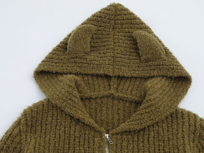 Close-up of the olive-brown bear-ear hood showing plush knit texture and hood opening