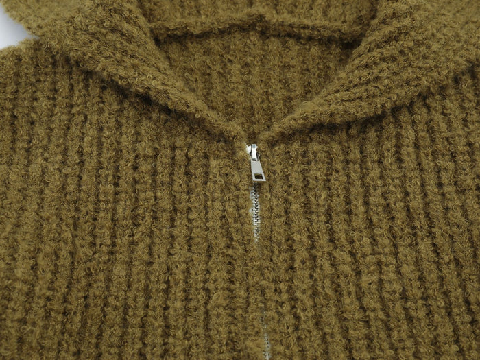 Close-up of olive-brown fuzzy knit fabric around the hood and silver front zipper