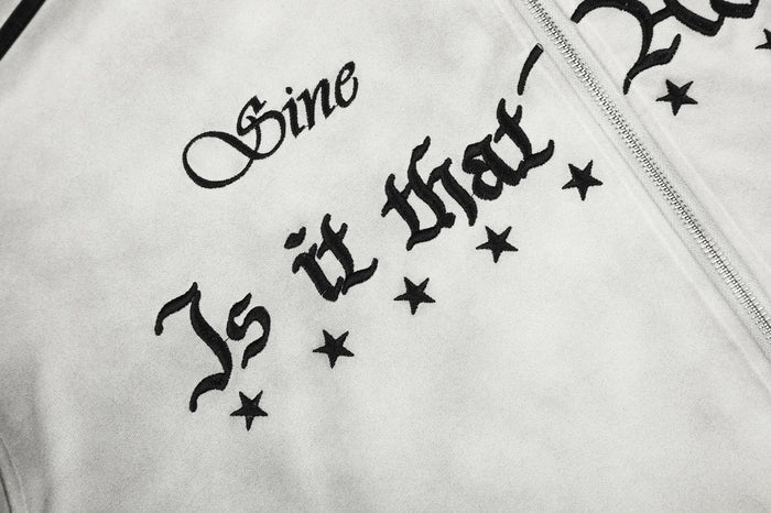 Close-up of black gothic-style lettering and star graphics printed on the gray hoodie chest