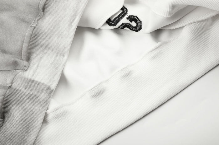 Close-up of the hoodie’s soft light-gray fabric, inner seam, and ribbed sleeve cuff