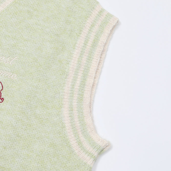 Close-up of the pale green vest's striped ribbed armhole trim and soft knit texture