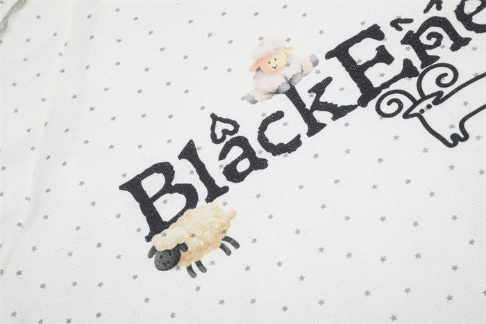 Detailed view of the Black Energy lettering with sheep and small figure illustrations on the star-print shirt