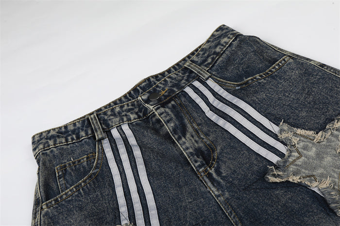Close-up of the waistband and front pocket on washed denim shorts with stripe detail