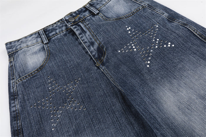 Close-up of front upper jeans showing two rhinestone star designs and faded wash