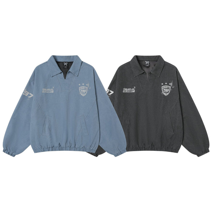 Two pullover training jackets in washed blue and charcoal with polo collars and white varsity-style graphics