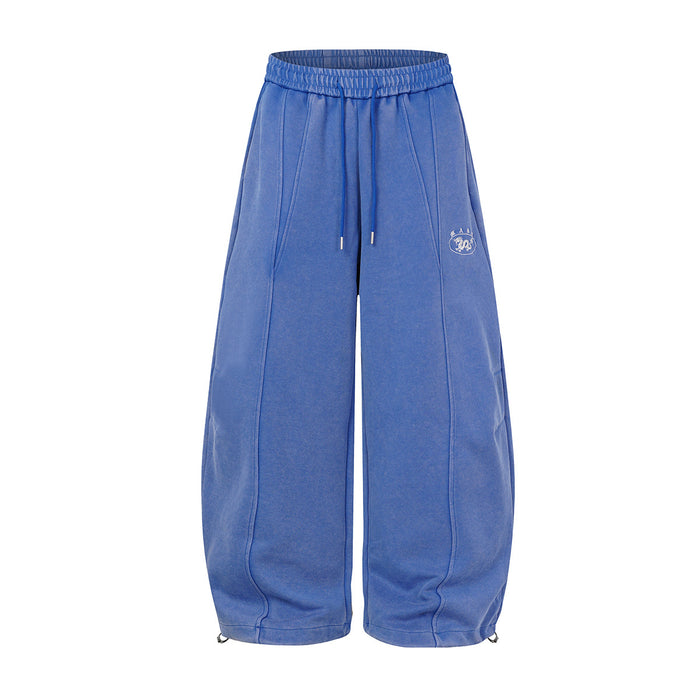 Oversized wide-leg acid wash sweatpants in blue with balloon silhouette, front seam detail, and drawstring hem