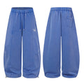Blue wide-leg sweatpants shown front and back, featuring stitched leg panels, drawstrings, and a back pocket