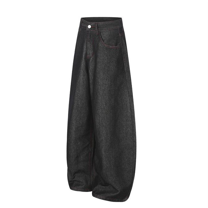 Three-quarter front view of black wide-leg jeans with red stitching and a curved barrel silhouette
