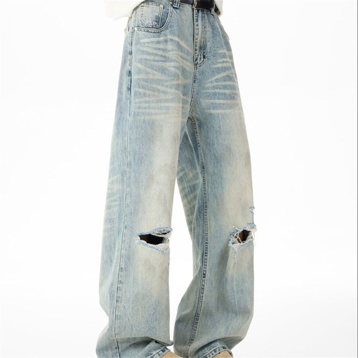 Angled front view of light-wash wide-leg jeans showing belt loops, pockets and distressed knees