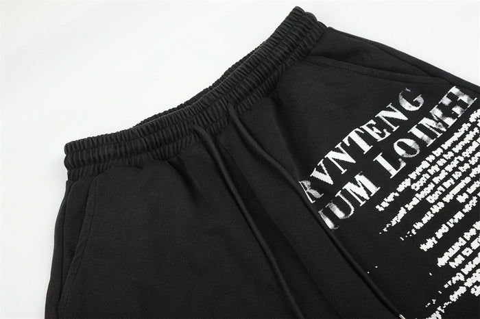 Black sweatpants waist detail with elastic band and printed graphic at hip
