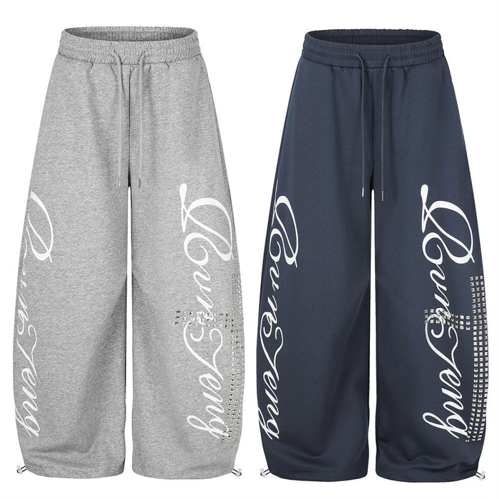 Gray and navy wide leg sweatpants with white script graphic and rhinestone cross detail, front views