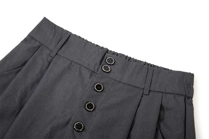 Close-up of black culottes shorts waistband and button fly with pleated front