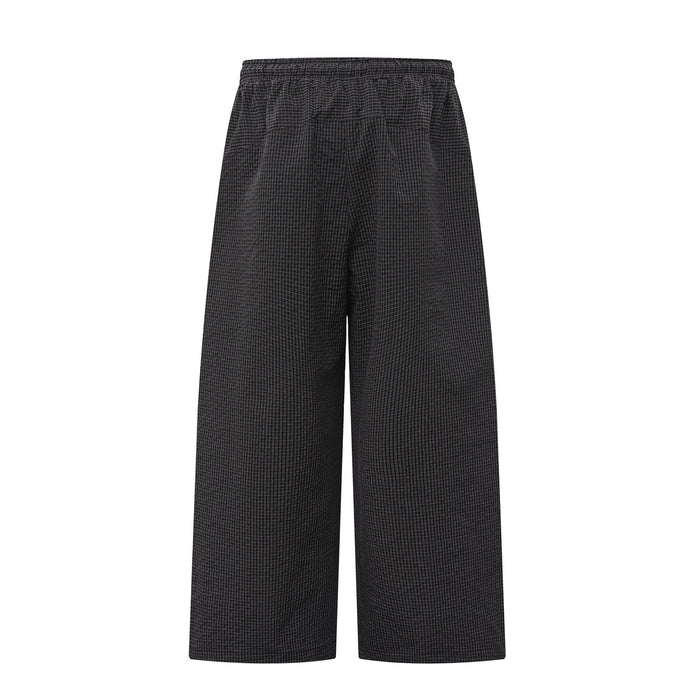 Black textured check wide-leg pants shown from the back with elastic waistband and relaxed drape