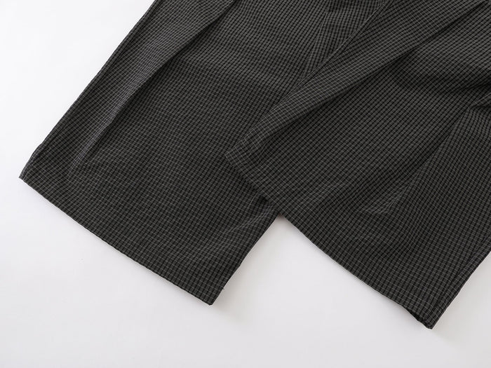 Close-up of the pant hems showing wide legs and fine black-and-white check texture