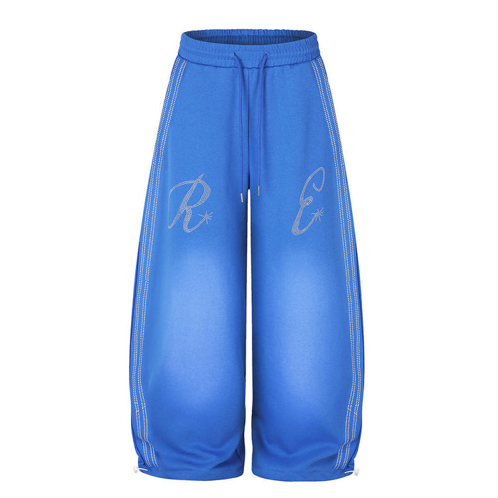 Men's oversized wide-leg sweatpants in blue with rhinestone letter graphics and side stripe detailing