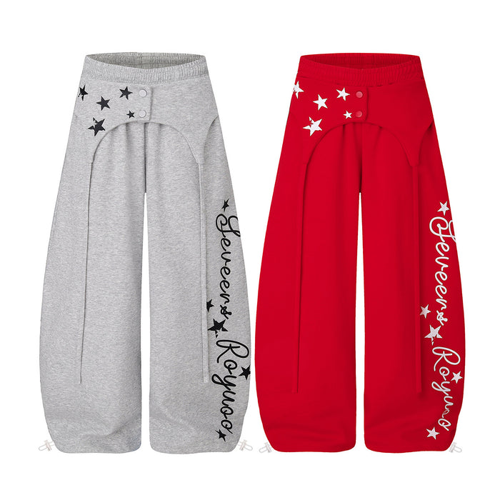 Gray and red wide-leg sweatpants with star prints, snap-tab waist details, and script graphics on the legs