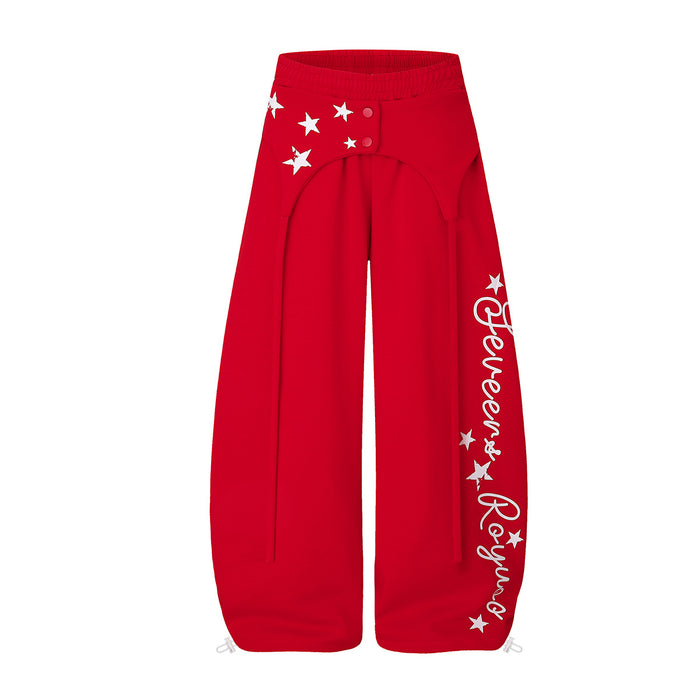 Front view of red wide-leg sweatpants with white stars, a snap-tab waist, and script leg graphics