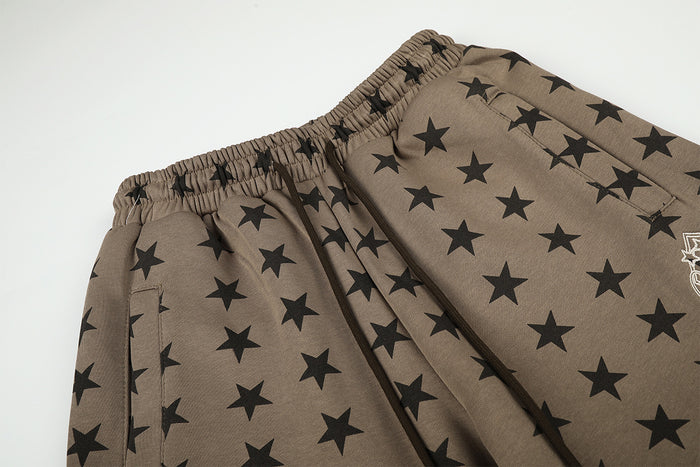Close-up of the elastic waistband and black star print on taupe wide-leg sweatpants