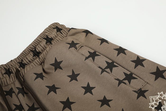 Detailed view of taupe textured fabric with black stars and a partial white graphic near the pocket
