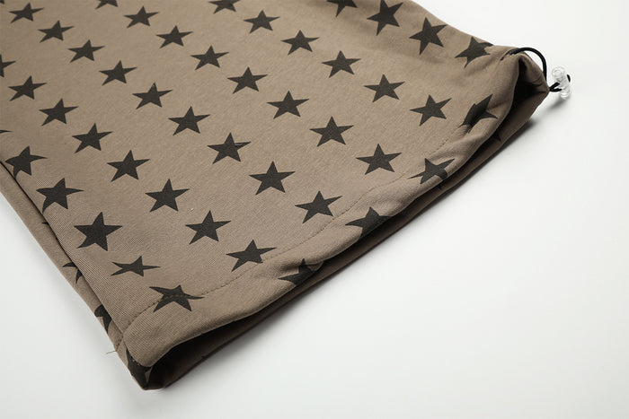Close-up of a star-print pant leg hem showing the folded edge and small silver adjustment hardware