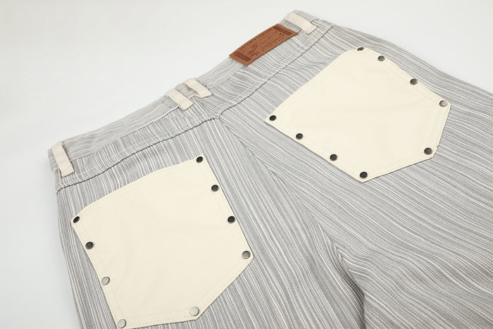 Close-up back view showing cream patch pockets, dark rivets, belt loops, and brown waistband label