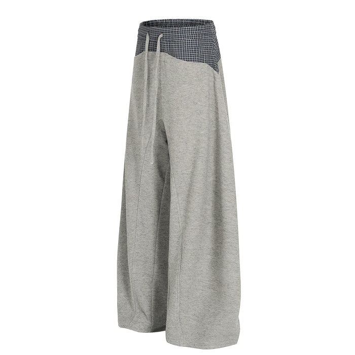 Wide-leg gray sweatpants with navy plaid contrast waistband, angled side view