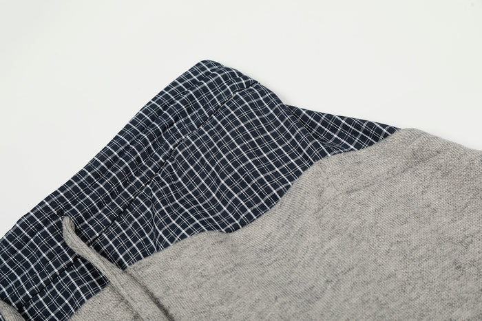 Close-up of navy plaid waistband and gray upper panel on sweatpants