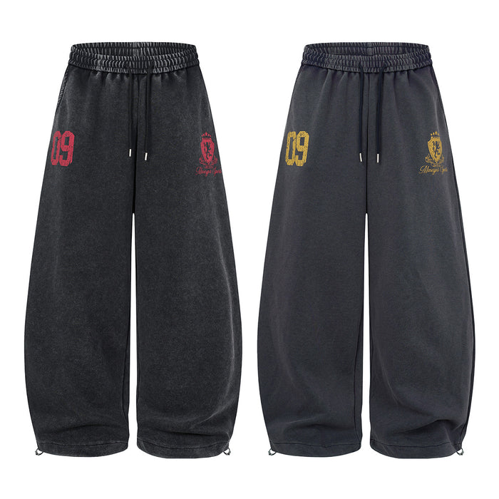 Wide-leg acid-wash sweatpants shown in black with red graphics and dark gray with yellow graphics, front view