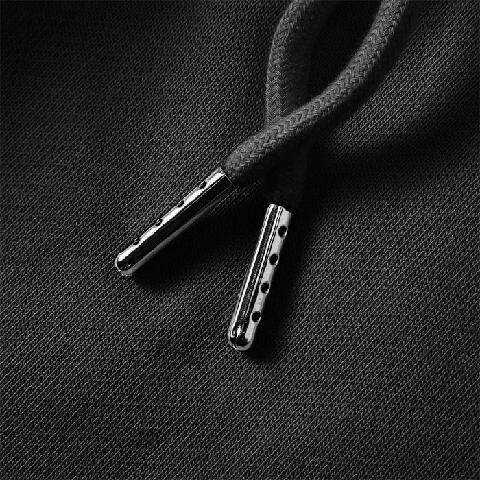Close-up of black sweatpants drawstring with textured cord and silver-toned metal tips