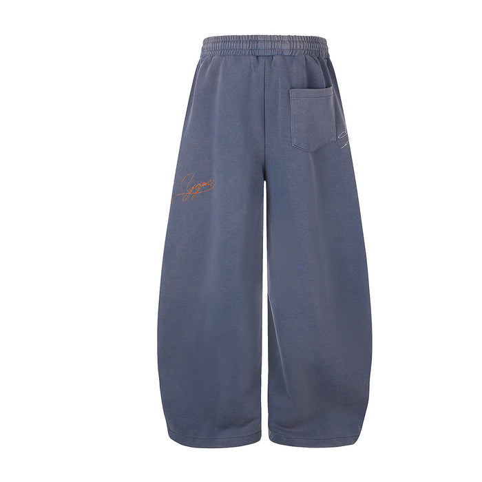 Back view of blue wide-leg sweatpants with a rear pocket and small orange graffiti embroidery