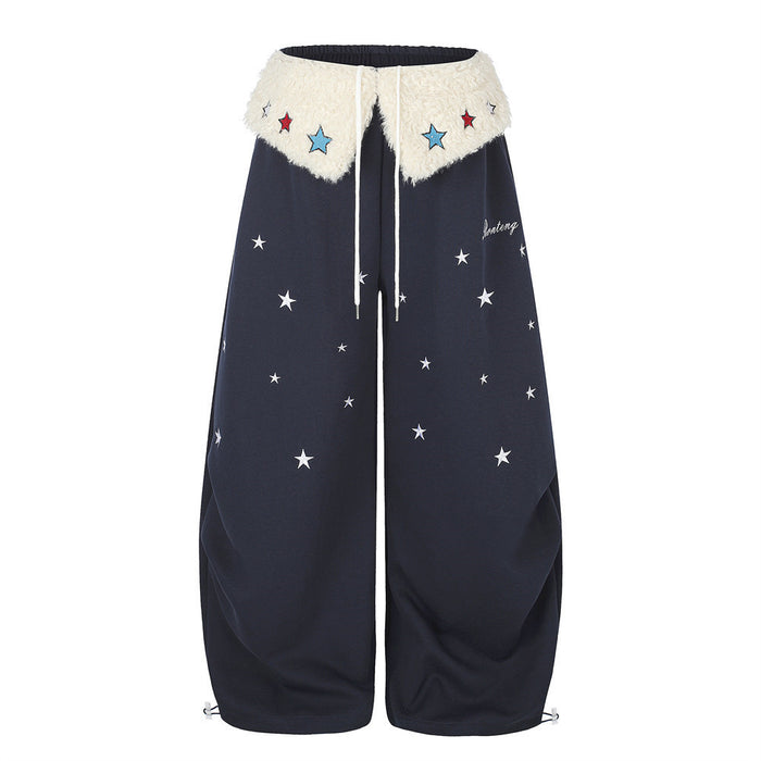 Wide-leg sweatpants with cream sherpa fold-over waistband, colorful star embroidery patches, and all-over white star print in